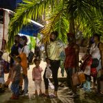 Familias venezolanas esperan un autobús que los lleve a la frontera. Habían caminado durante semanas, a menudo cargando niños a sus espaldas.